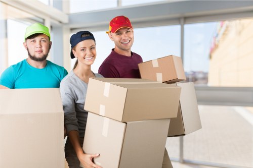 Professional mover planning a careful lift with protective equipment nearby